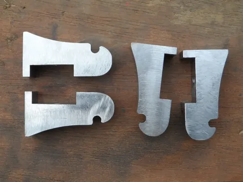 Pièces plates à profils découpés présentées dans l’atelier.